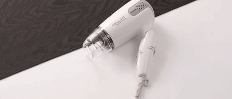 A white hair dryer with a cord on a white surface.