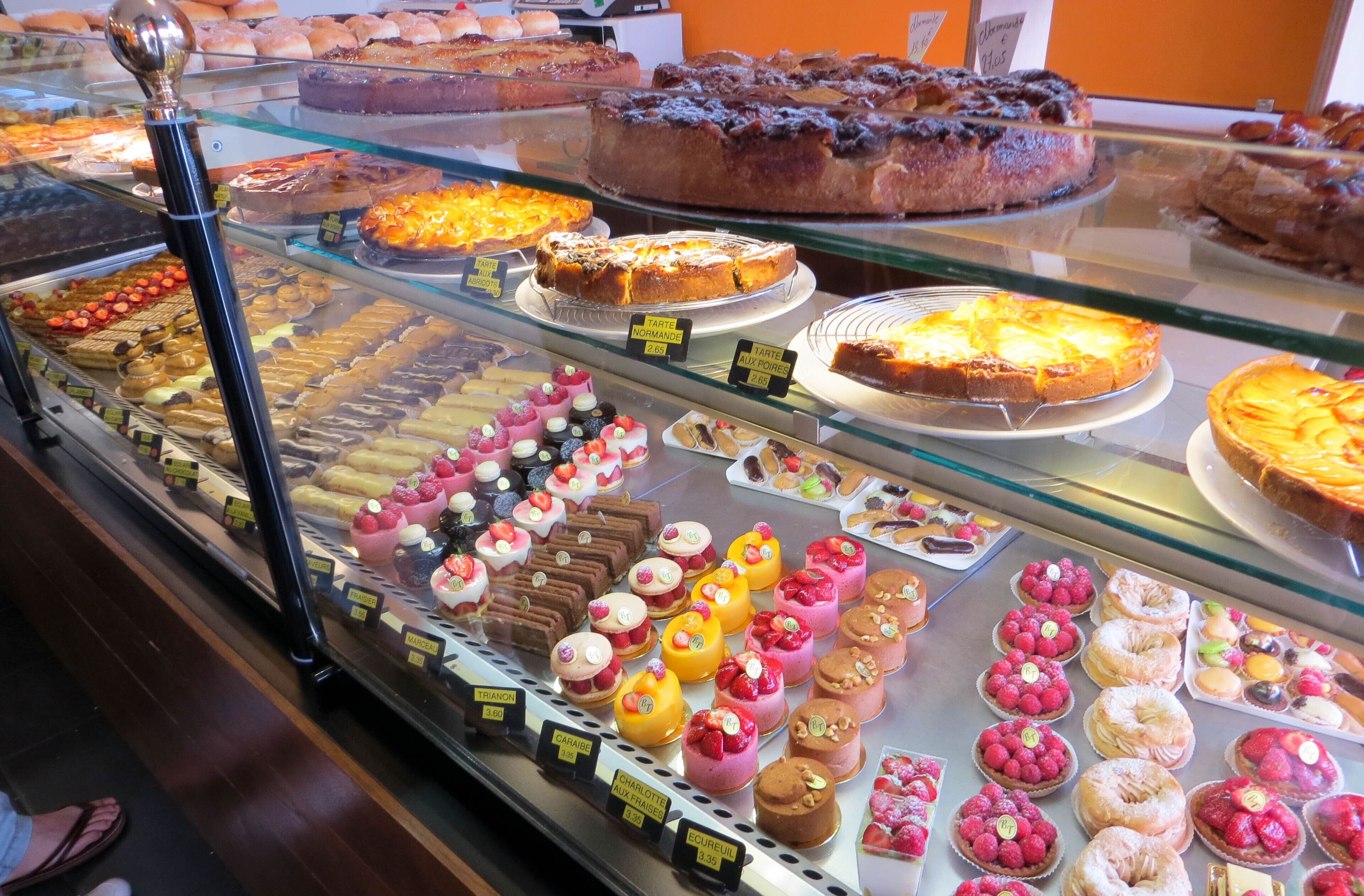 Vitrina de pastelería con diversos pasteles y postres.