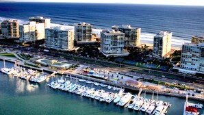An aerial view of a marina with multiple boats docked, surrounded by high-rise buildings and a coastal cityscape. - Charming Guesthouse Studio To  Elegant 1920s Spanish Home (Coronado)