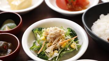 Variedad de platos, incluyendo un tazón de sopa con verduras y pollo, un plato de arroz, y varios cuencos pequeños con diferentes alimentos.
