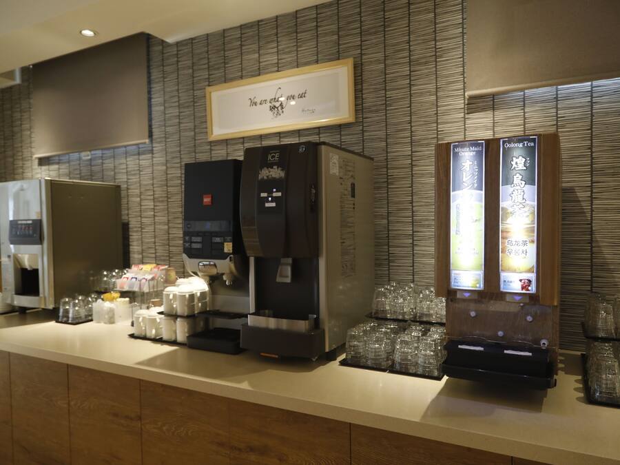 Een koffiehoek met meerdere koffieapparaten en een drankenspender.