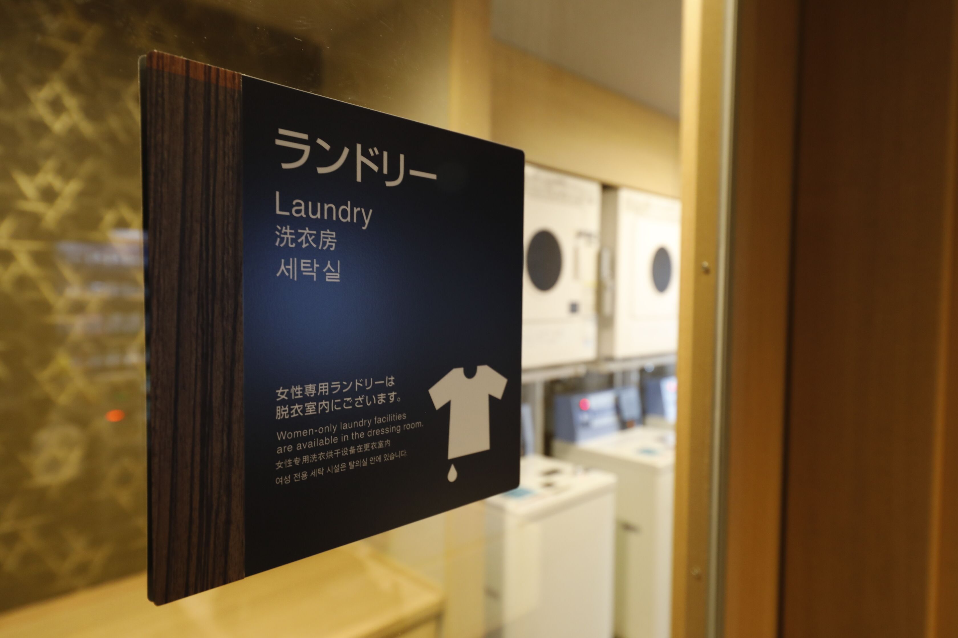 A sign indicating a women-only laundry room with a t-shirt icon.