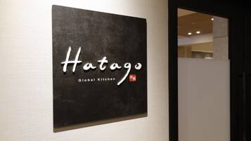 Letrero que dice 'Hatago Global Kitchen' en una pared.