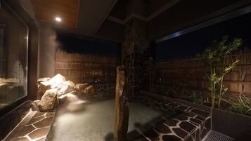 A hot spring area with stone walls and a wooden ceiling.
