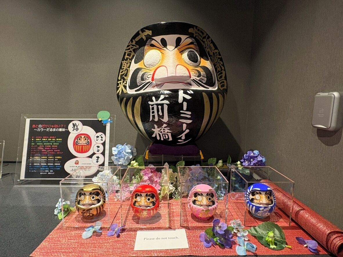 A display of traditional Japanese dolls and a large decorative bowl with Japanese text.