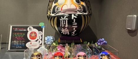 Una exhibición de muñecas tradicionales japonesas y un recipiente decorativo grande con texto en japonés.