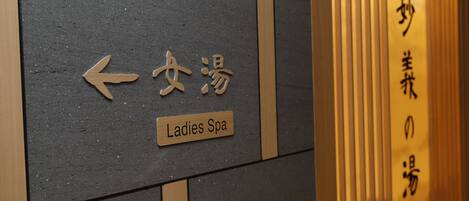 A sign indicating the direction to the Ladies Spa with an arrow pointing left.