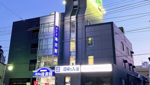 A hotel with a modern design, featuring a prominent neon sign and a large entrance.