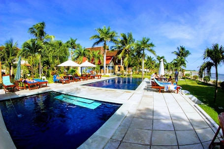 Outdoor pool, pool loungers. Aman Gati Hotel Lakey