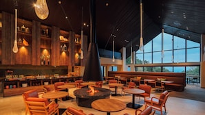 A spacious indoor area with wooden furniture, a central fire feature, and large windows allowing natural light. - The Key Highland Nasu (Nasu)