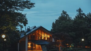 A modern house with large windows and a covered entrance, surrounded by trees and a well-maintained garden. - The Key Highland Nasu (Nasu)