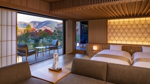 A modern hotel room with a balcony, a sofa, a bed, and a view of mountains. - Hoshino Resorts KAI Sengokuhara (Hakone)