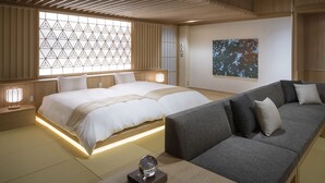 A modern hotel room with a large bed, a sofa, a decorative wall, and a large window with a geometric pattern. - Hoshino Resorts KAI Sengokuhara (Hakone)