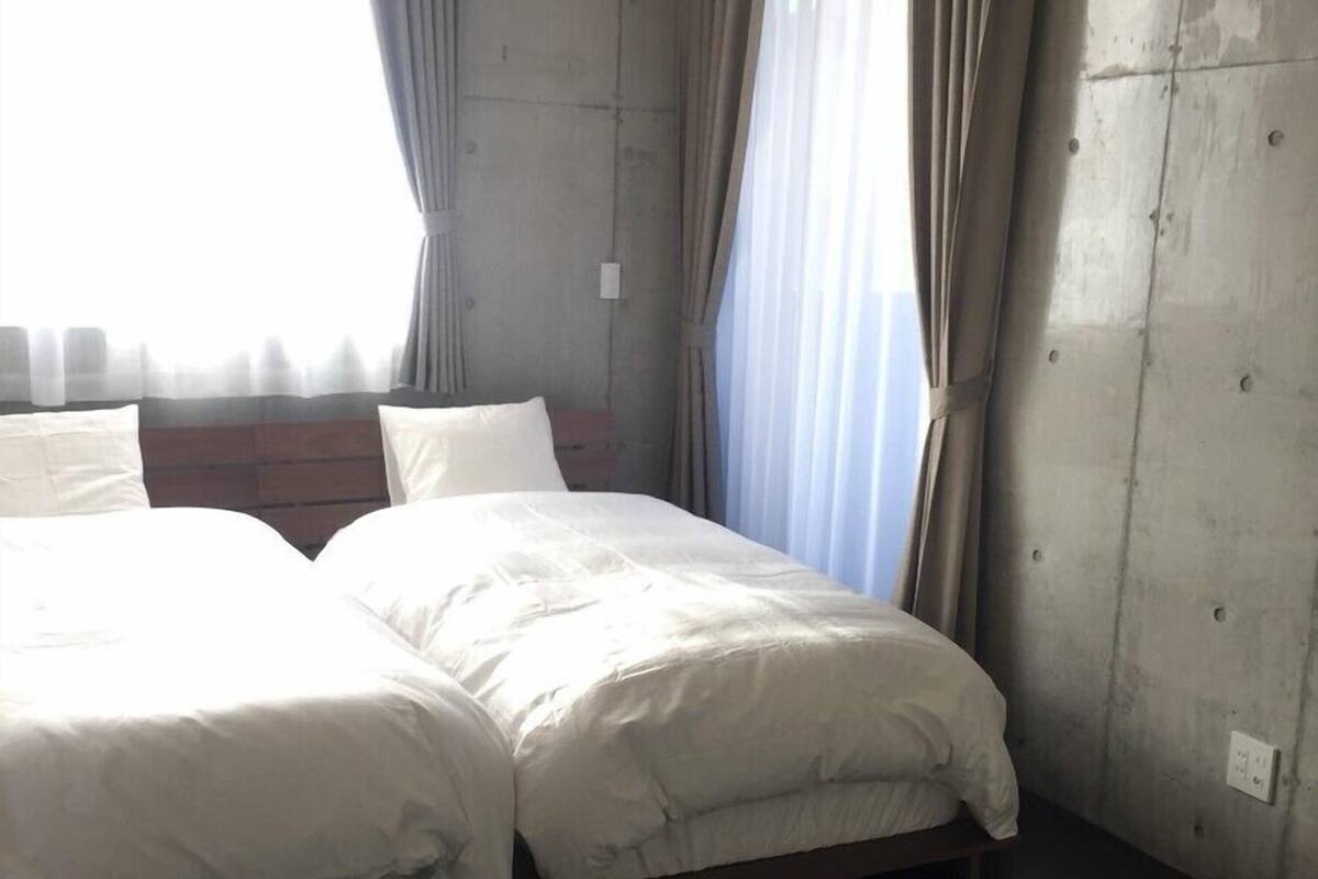 Une pièce avec un lit, des rideaux et une fenêtre.