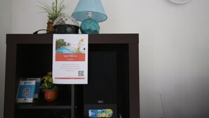 A room with a clock on the wall, a lamp, a potted plant, and a framed picture. - Bali Tropicana Pool Villa (Pattaya)