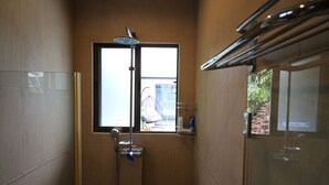 A shower with a window, a towel rack, and a small shelf with toiletries. - Bali Tropicana Pool Villa (Pattaya)