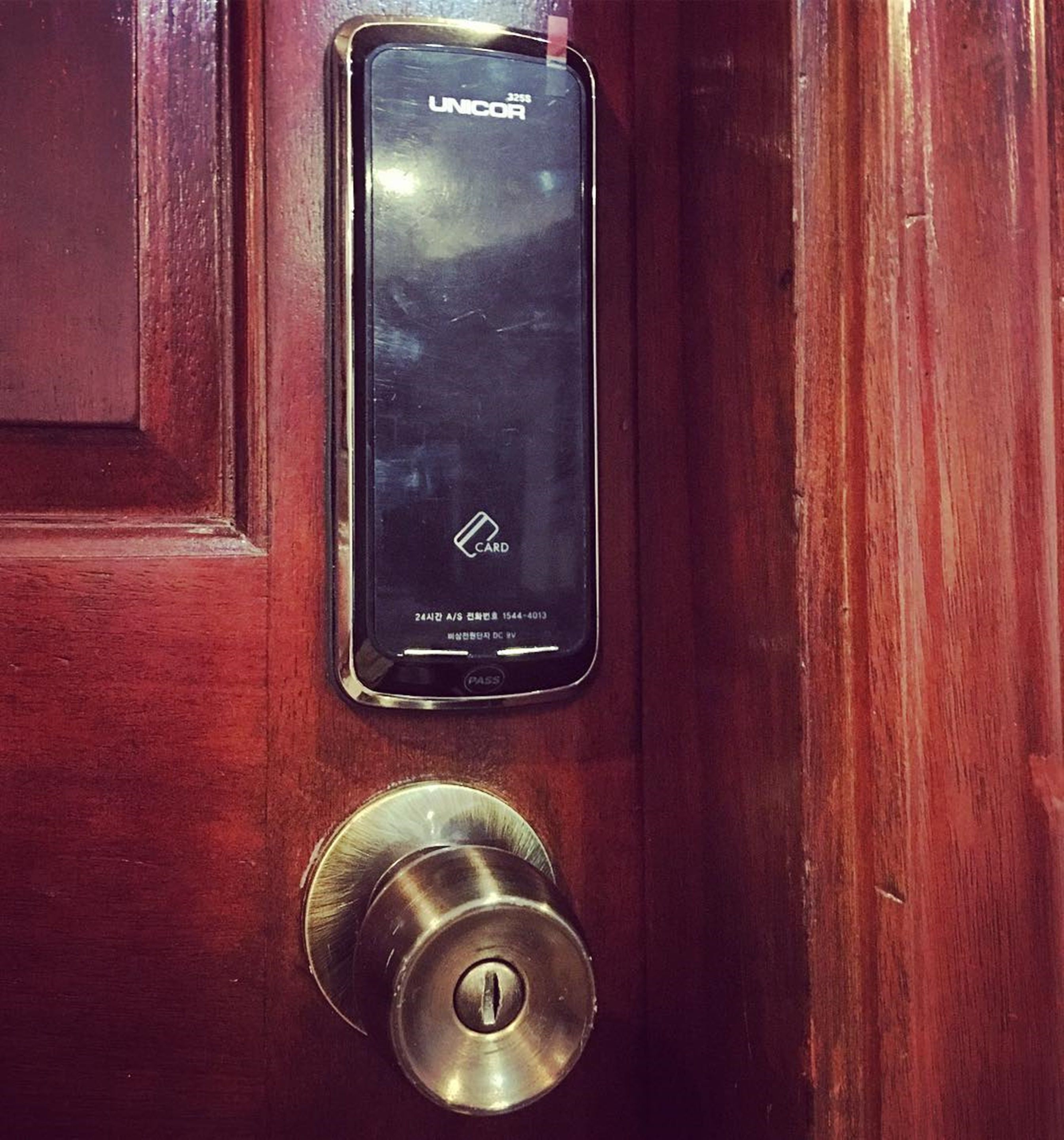 A door with a card reader labeled "UNICOR" and a keyhole below it.