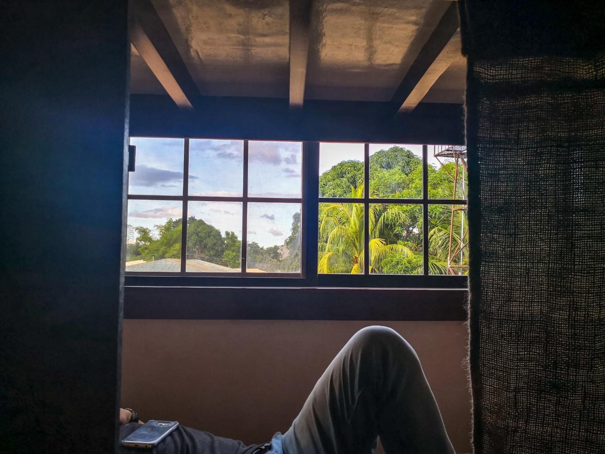 A room with a window overlooking a lush green landscape.