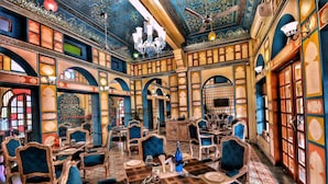 A traditional interior with ornate arches, patterned carpets, and classic furniture. - Nirbana Palace - A Heritage Hotel (Jaipur)
