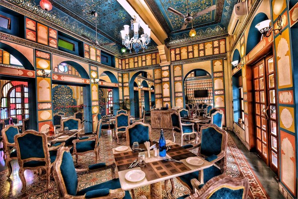 A traditional interior with ornate arches, patterned carpets, and classic furniture. - Nirbana Palace - A Heritage Hotel (Jaipur)