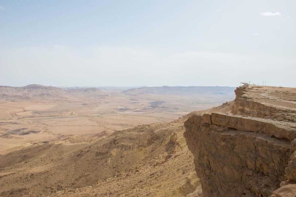 A desert landscape with a rocky cliff edge.