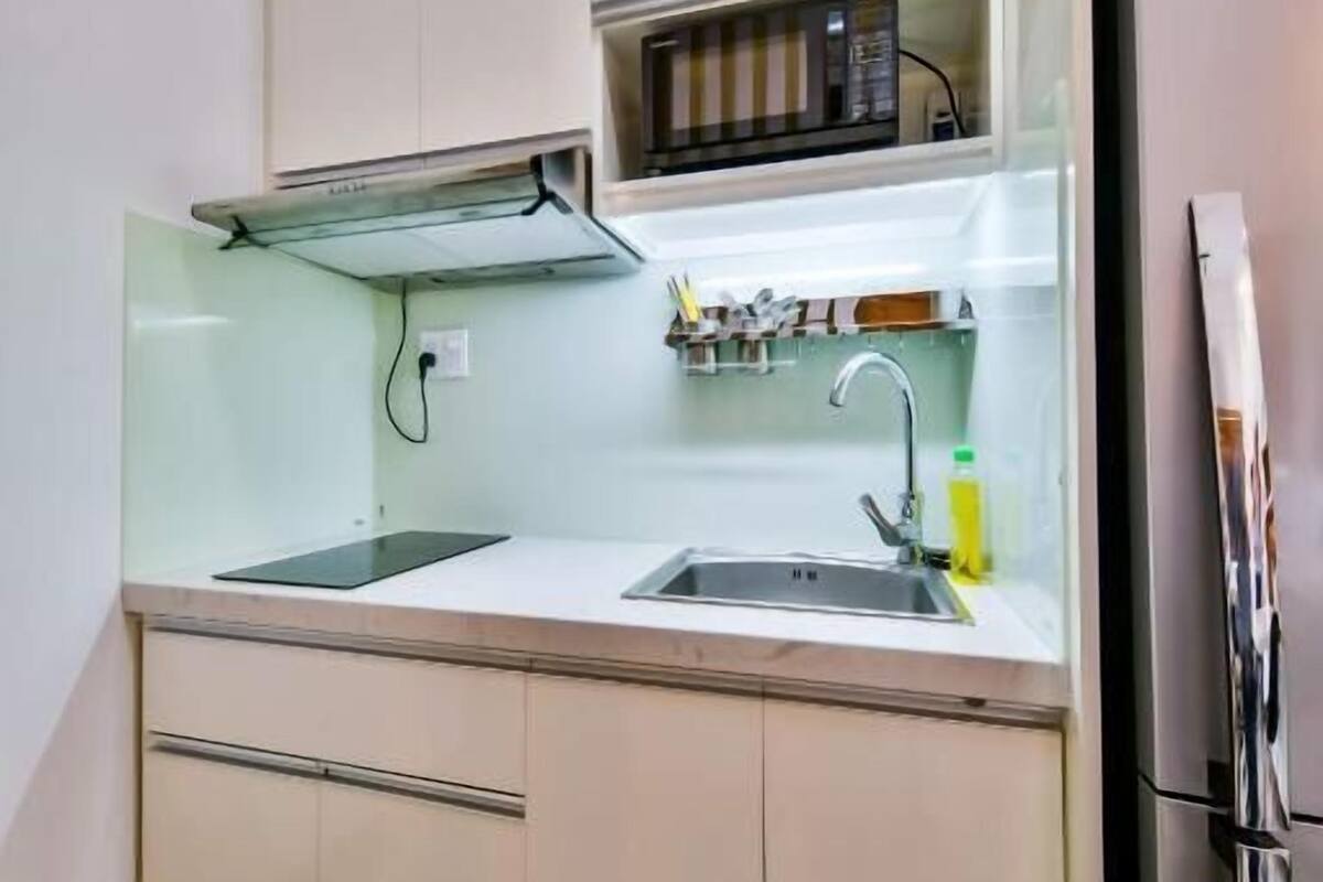 A modern kitchen with a stainless steel refrigerator, a double sink, and a built-in oven.