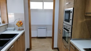 Une cuisine moderne avec des meubles en bois, un four encastré et un four à micro-ondes.