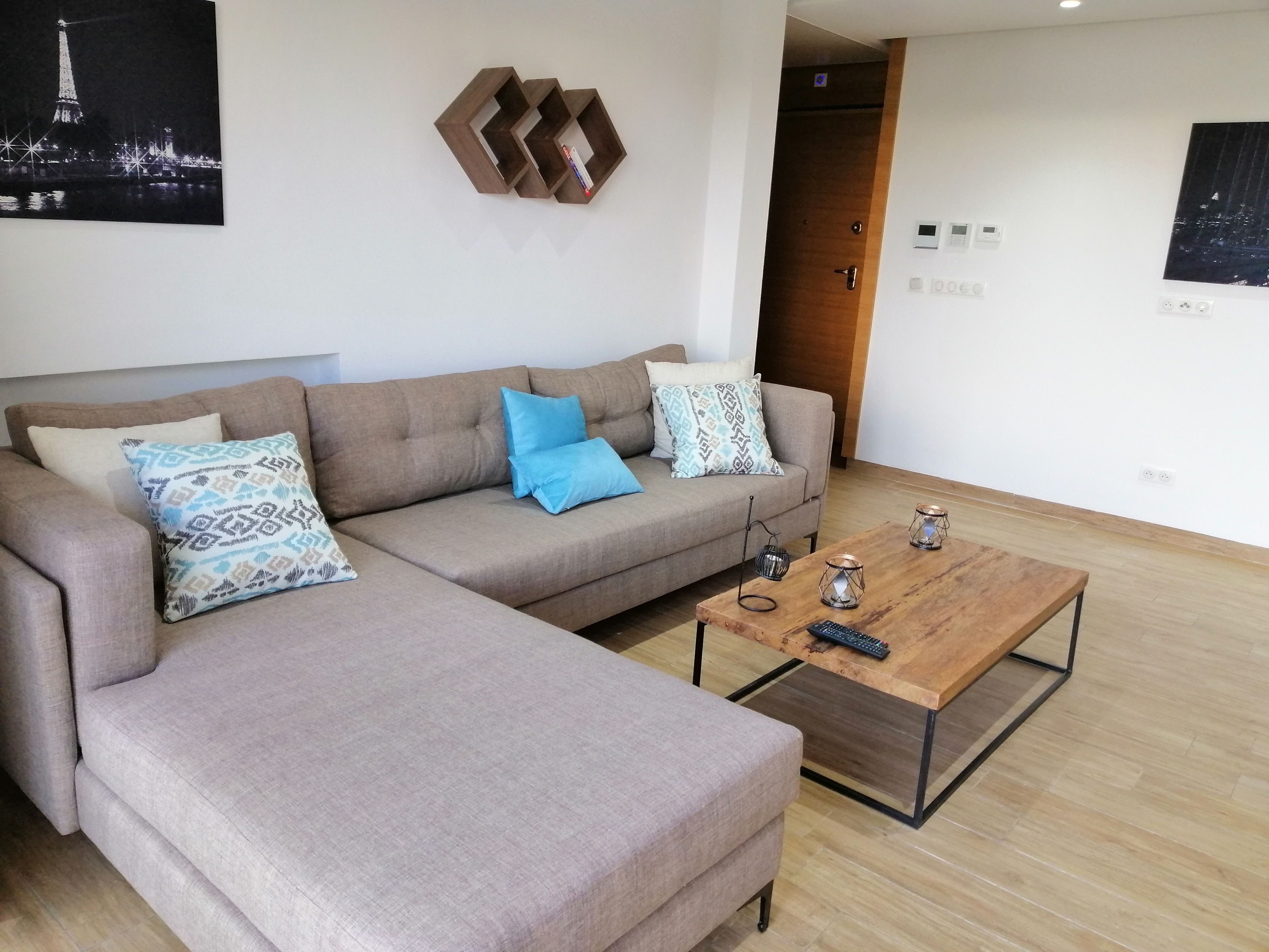 Ein modernes Wohnzimmer mit einer Couch, einem Couchtisch und einem an der Wand befestigten Regal.