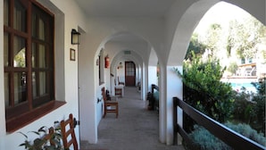 A covered corridor with benches, a fire extinguisher, and a door labeled "SALIDA". - Posada San Bras (Villa General Belgrano)