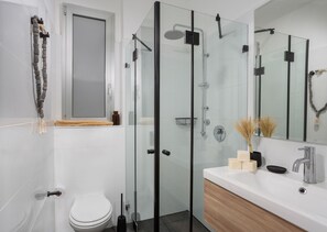 A modern bathroom with a glass-enclosed shower, a white toilet, and a vanity with a mirror. - Mr. Yavos - By TLV2GO (Tel Aviv)