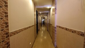 Ein langer, schmaler Gang mit Wänden im Steinoptik und Holzboden.