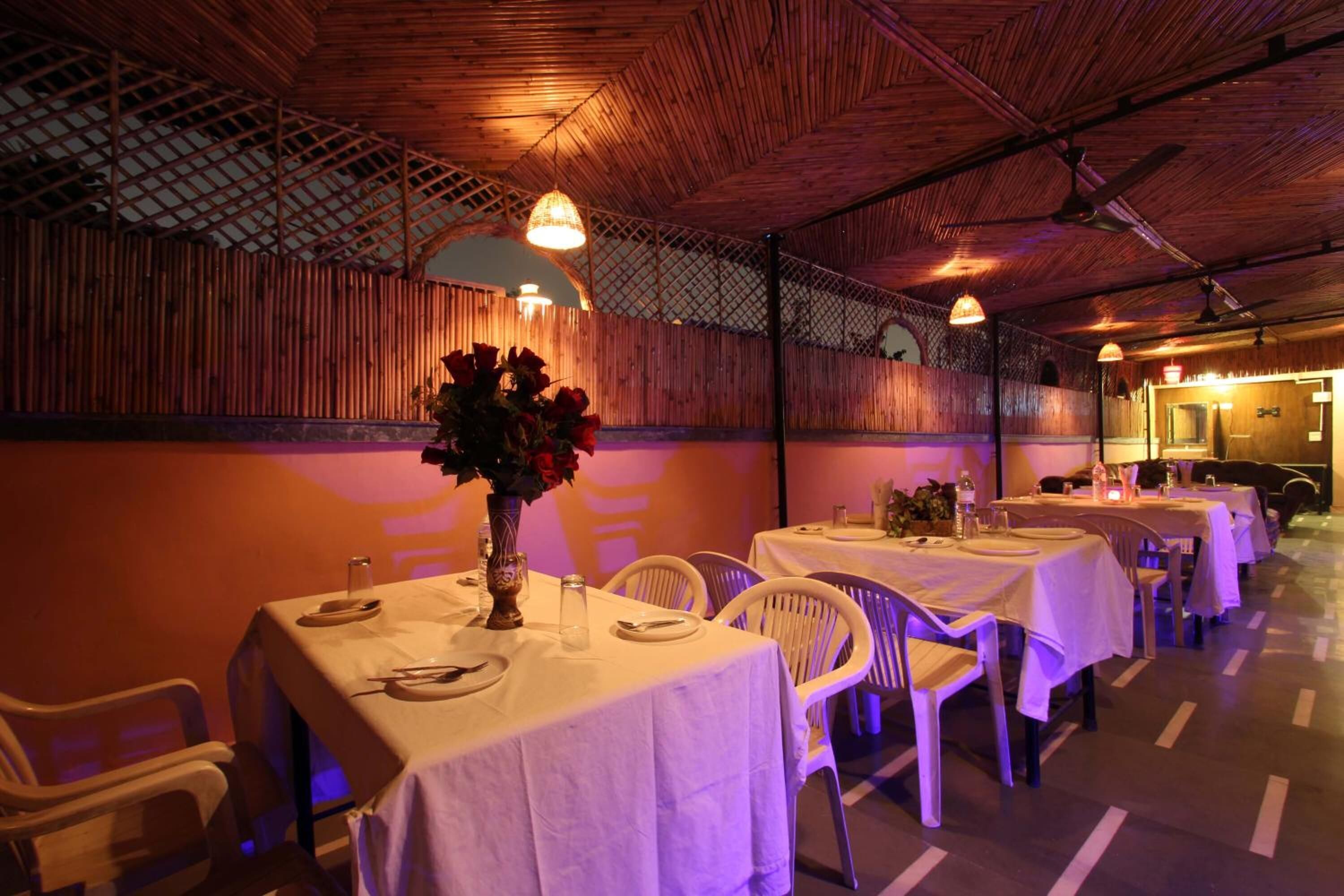 Un restaurant doté de nombreuses tables, chacune étant recouverte d’une nappe blanche et agrémentée de chaises.
