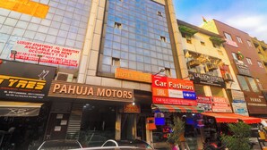 A multi-story building with various commercial establishments on the ground floor, including a car dealership and a hotel. - Hotel Grace at Karol Bagh (New Delhi)