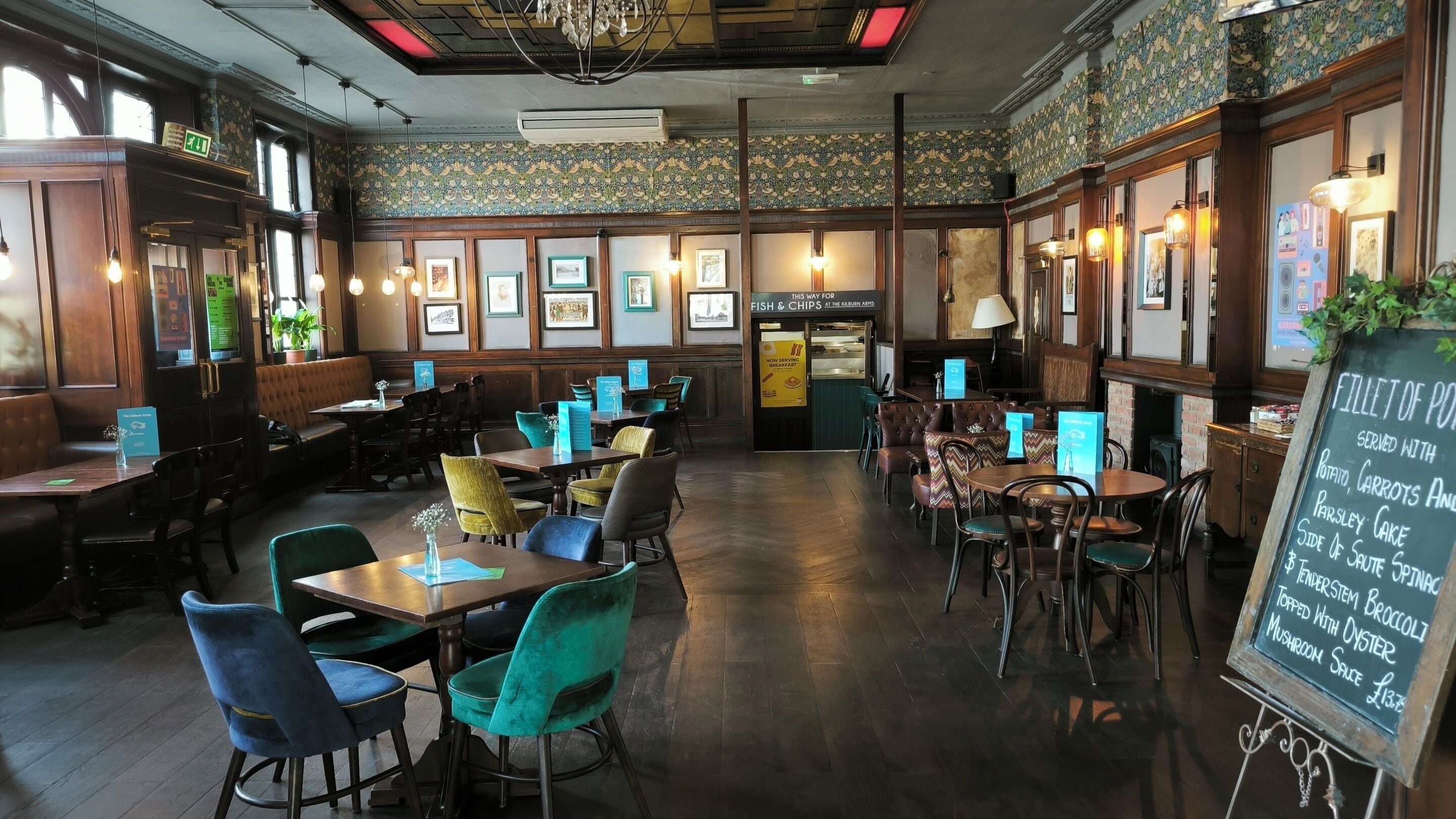 A restaurant interior with booths, tables, and a chalkboard menu.