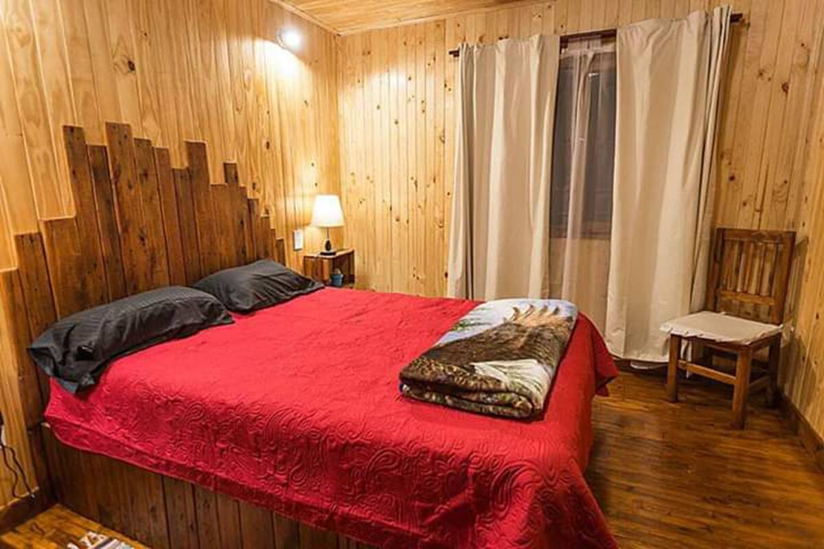 Cortinas opacas, tabla de planchar con plancha, ropa de cama