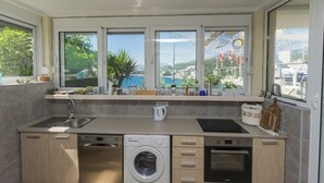 A modern kitchen with a built-in washing machine, oven, and sink.