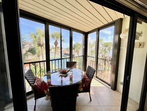 Relax on the balcony with a round table and four chairs, taking in the serene views of the lush garden and tennis court.