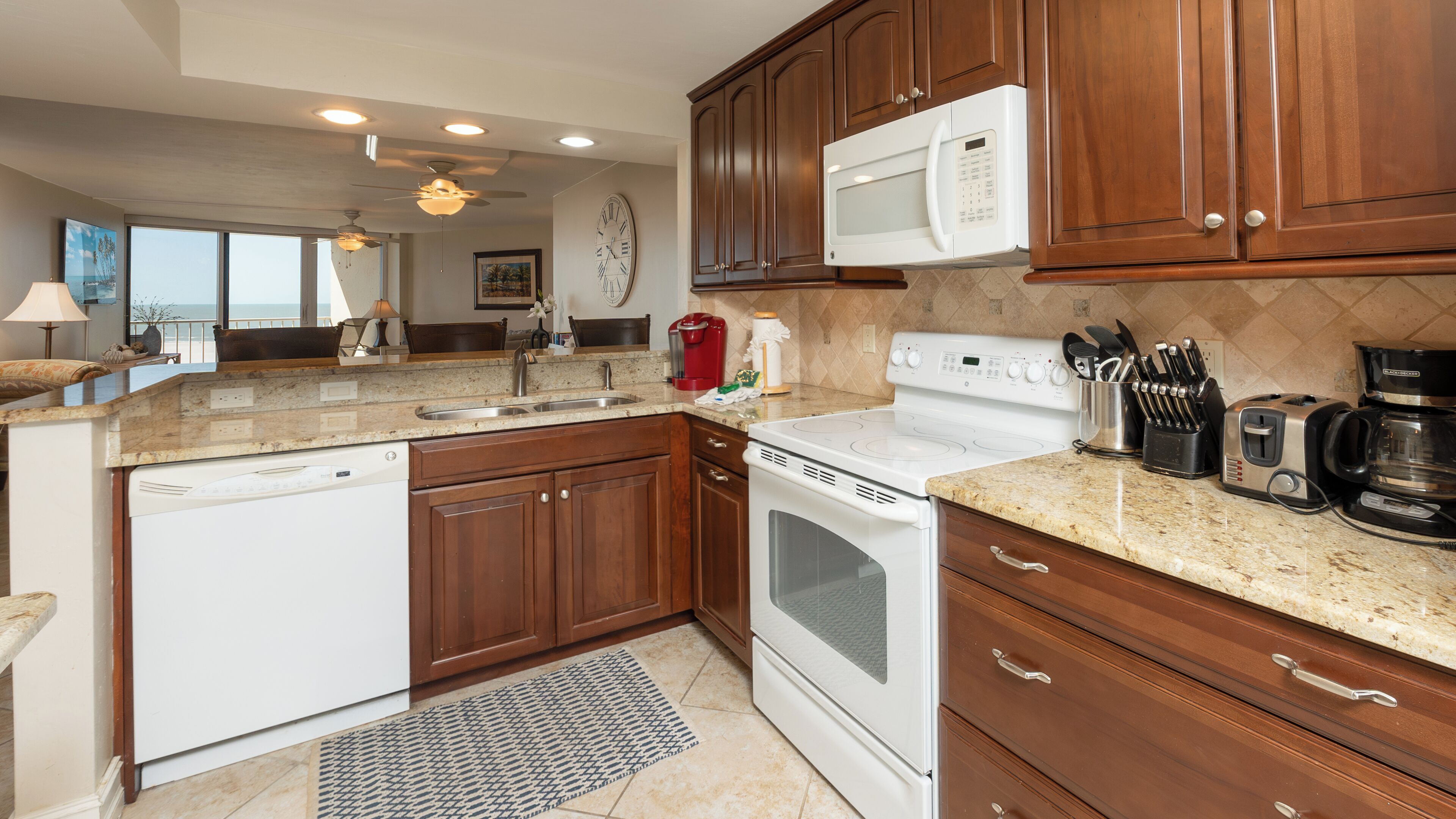 A modern kitchen with wooden cabinets, a white stove, a microwave, and a coffee maker.