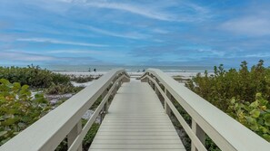 A wooden boardwalk leading to a beach with a clear sky. - Somerset 510- Beautiful Beach Front Condo! Lovely Beach Décor! (Marco Island)