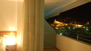 A balcony with a night view of a cityscape, including a lit-up building. - EXCELLENT APARTMENT NEXT BEACH (Tossa de Mar)