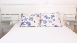 A bed with white bedding and two decorative pillows with blue patterns. - IDEAL FOR FAMILIES. COMFORT AND FUN (Felanitx)