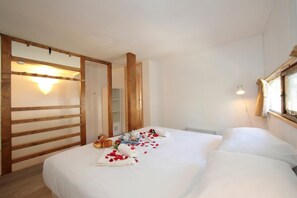 A bedroom with a bed, wooden headboard, bedside table, and a window with curtains. - Grand Roc C121 280m from Slopes, Parking & WiFi, Argentière (Chamonix), France (Argentière (Chamonix))