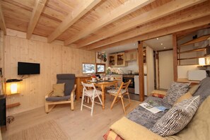 A cozy wooden interior with a dining area, kitchen, and seating space. - Grand Roc C121 280m from Slopes, Parking & WiFi, Argentière (Chamonix), France (Argentière (Chamonix))