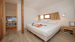 Une chambre à coucher avec un lit, une table de chevet et une fenêtre avec des rideaux.