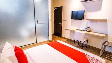 Une chambre d’hôtel équipée d’un lit, d’un bureau, d’une chaise, d’une télévision et d’un appareil de climatisation.