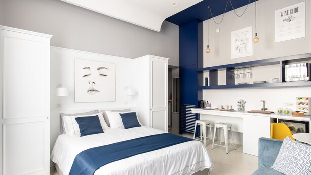 Un dormitorio moderno con cama, escritorio y sofá.