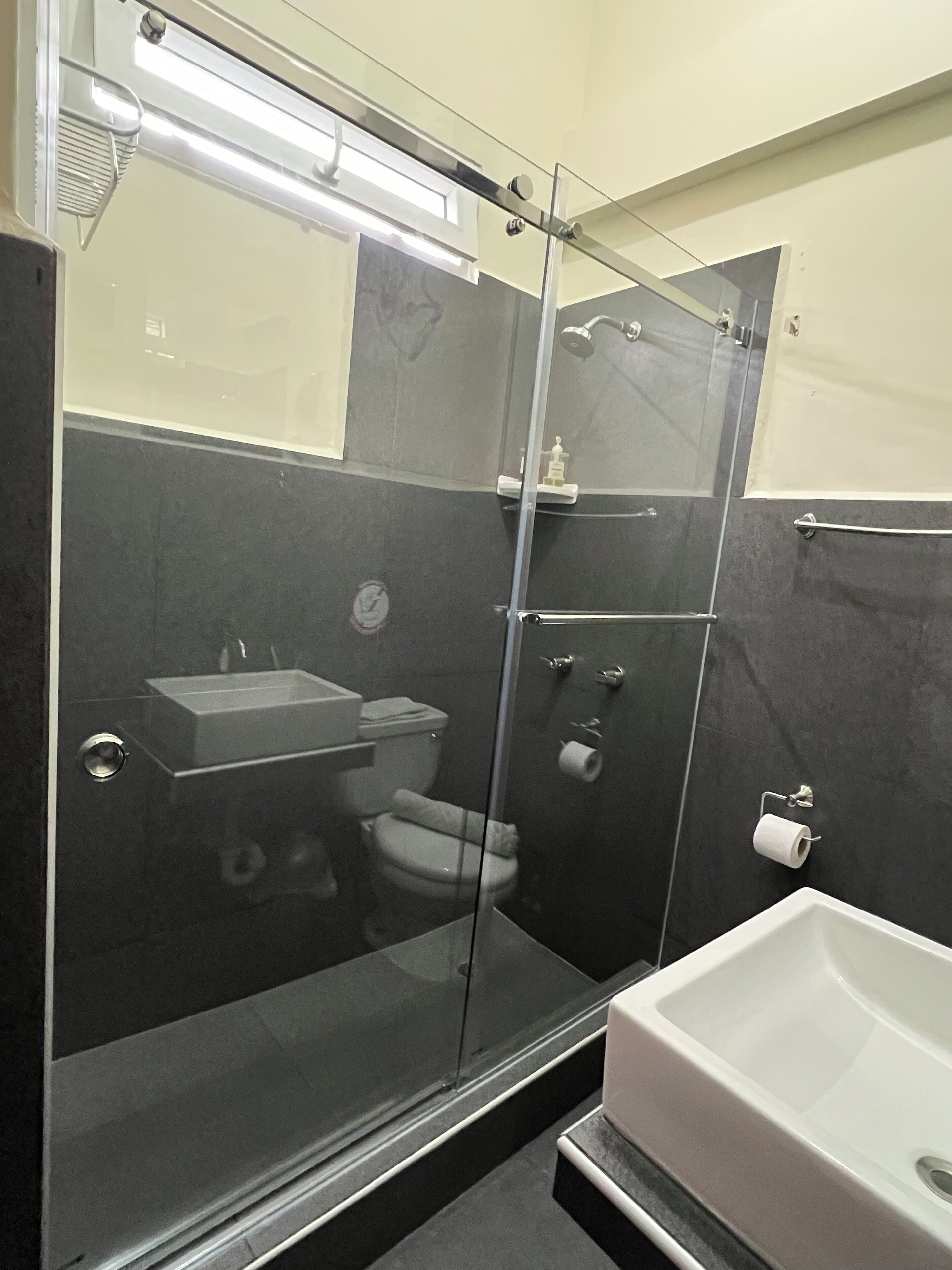 A modern bathroom with a glass-enclosed shower, a white sink, and a bathtub.