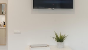 A flat-screen TV mounted on a white wall with the Netflix logo displayed. - AMAZING STUDIO in the CENTER of TOSSA (Tossa de Mar)