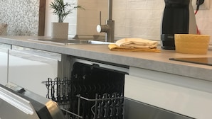 A modern kitchen with a built-in dishwasher, a coffee maker, and a sink with a faucet. - AMAZING STUDIO in the CENTER of TOSSA (Tossa de Mar)
