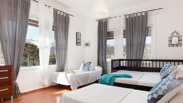 A room with two beds, a wooden dresser, and a small table with a lamp. - BEAUTIFUL HOUSE IN TOSSA (Tossa de Mar)